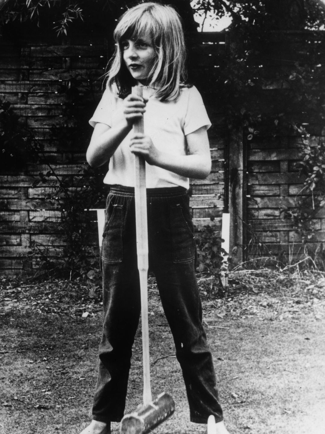 A young Princess Diana holding a croquet mallet