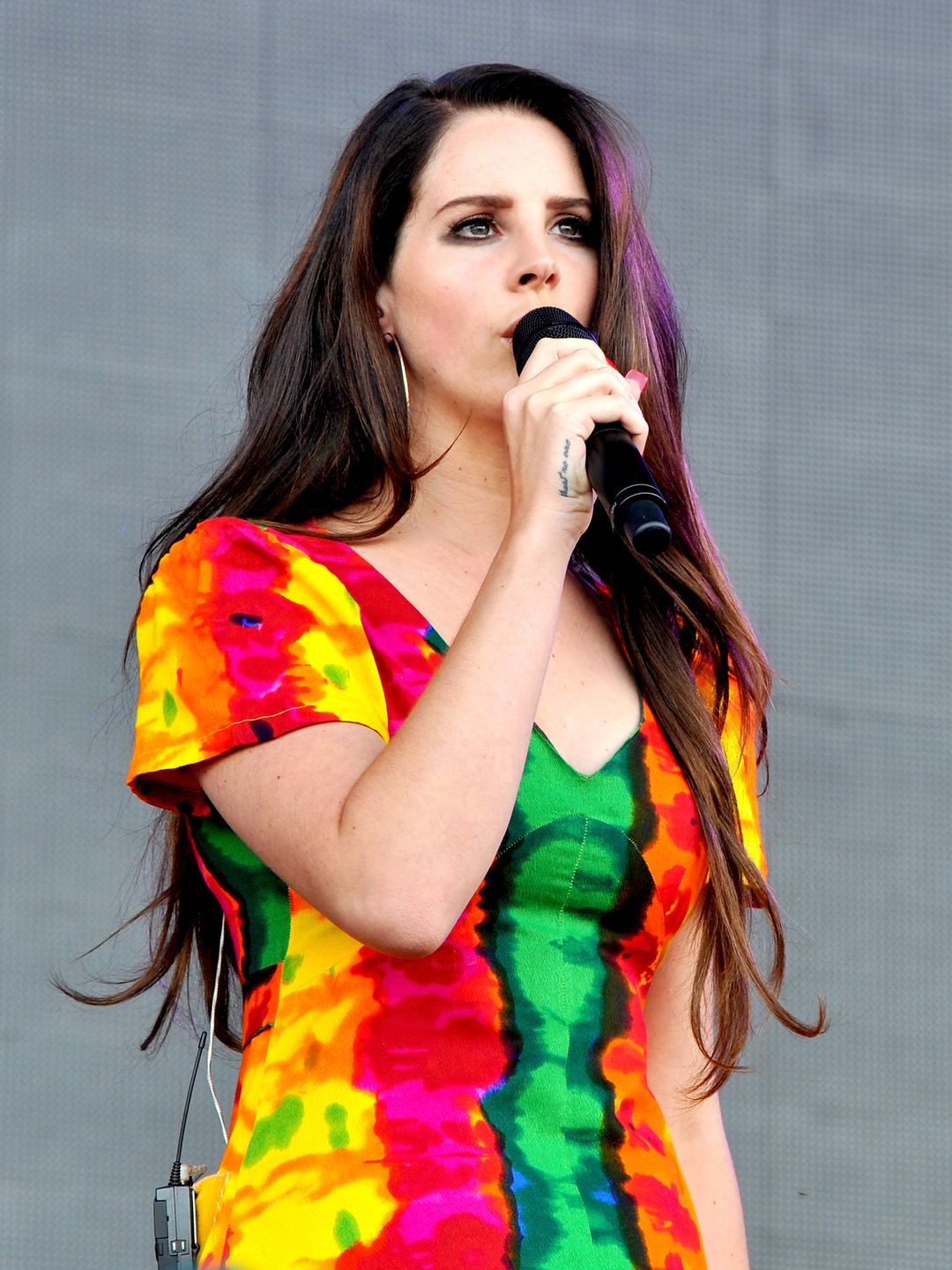 Lana Del Rey singing in a vibrant T-shirt dress 