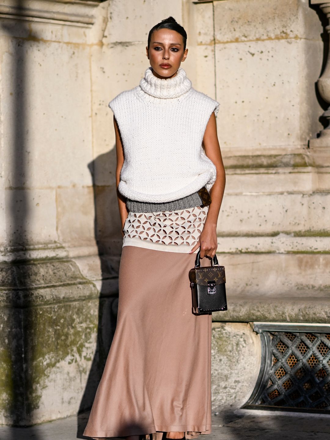  A guest is seen wearing a white Louis Vuitton sweater, pink skirt and brown Louis Vuitton handbag outside the Louis Vuitton show during Womenswear Spring/Summer 2025 as part of Paris Fashion Week on October 01, 2024 in Paris, France