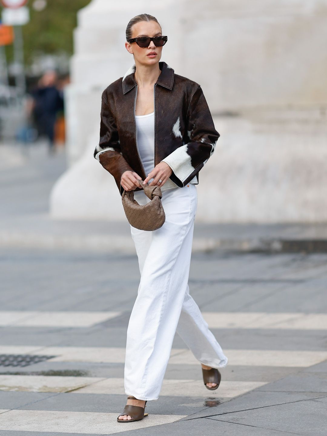 model in Cow print jacket, white trousers and brown accessories