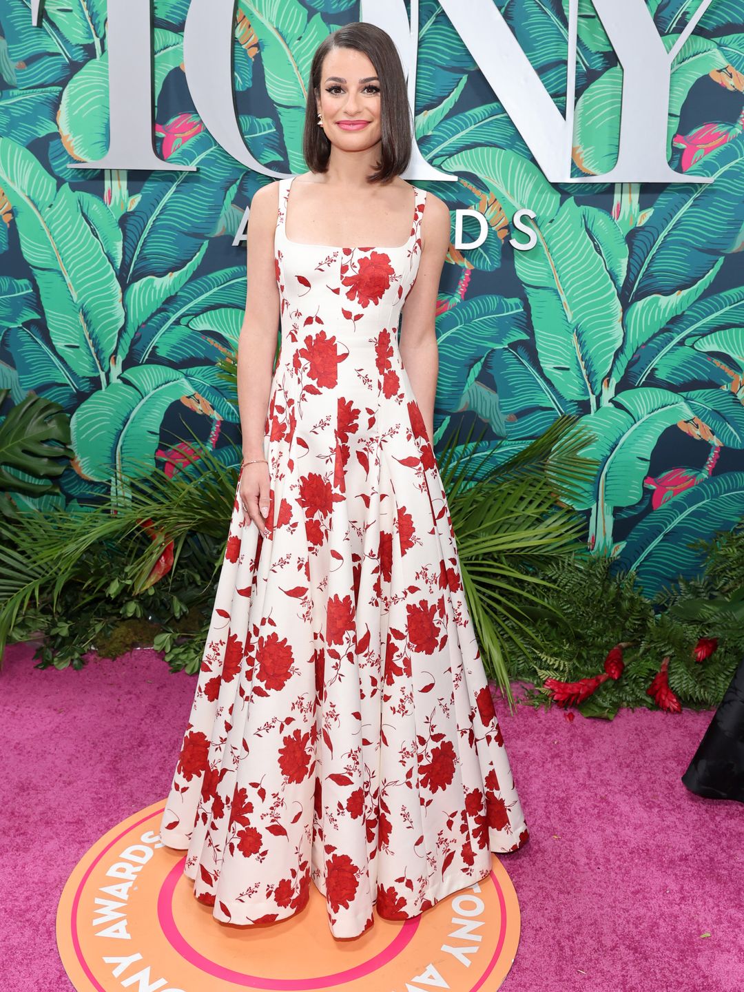 Lea Michele wearing a white square-neck gown with red florals 