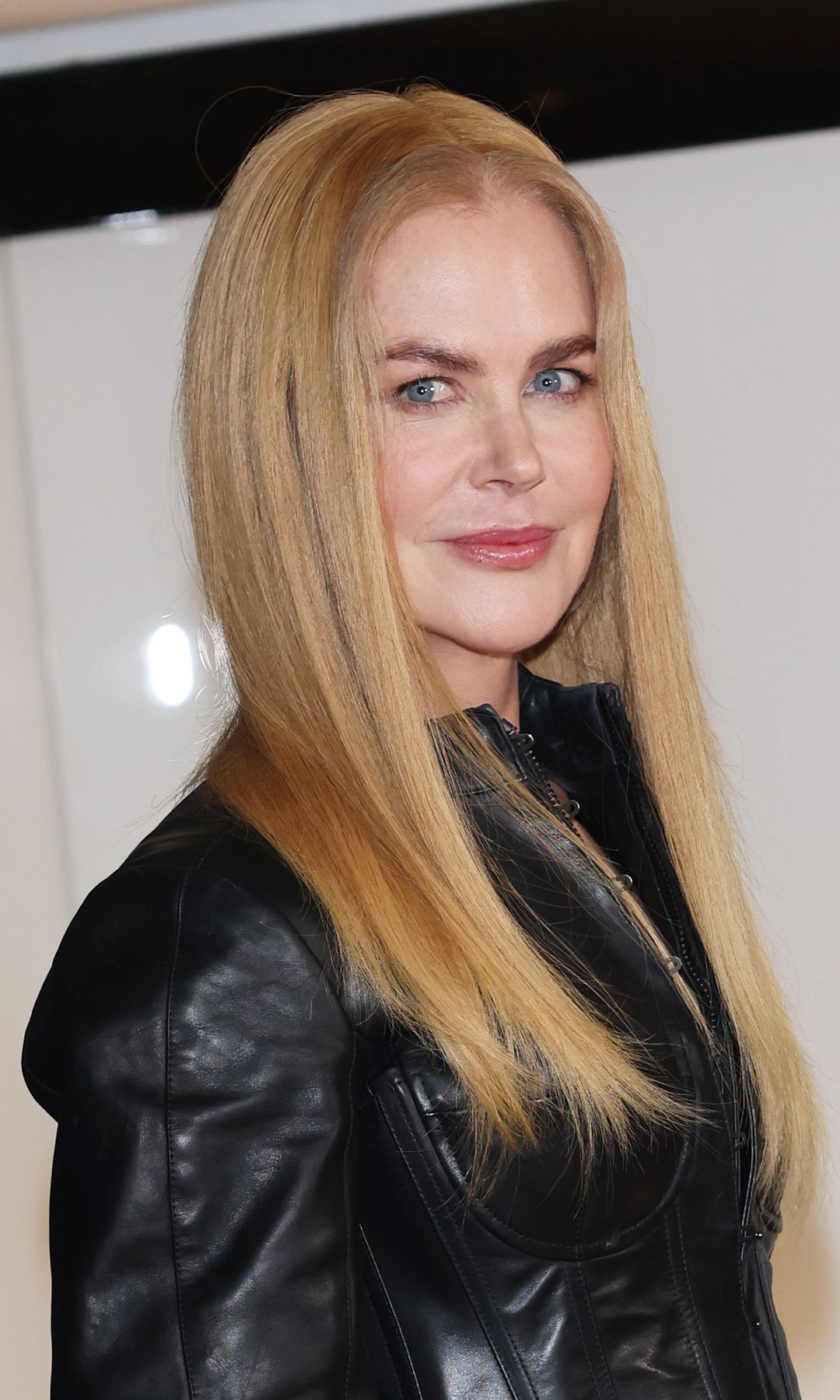 A close up of Nicole Kidman's long straight blonde hair, glossy radiant skin and pink lips