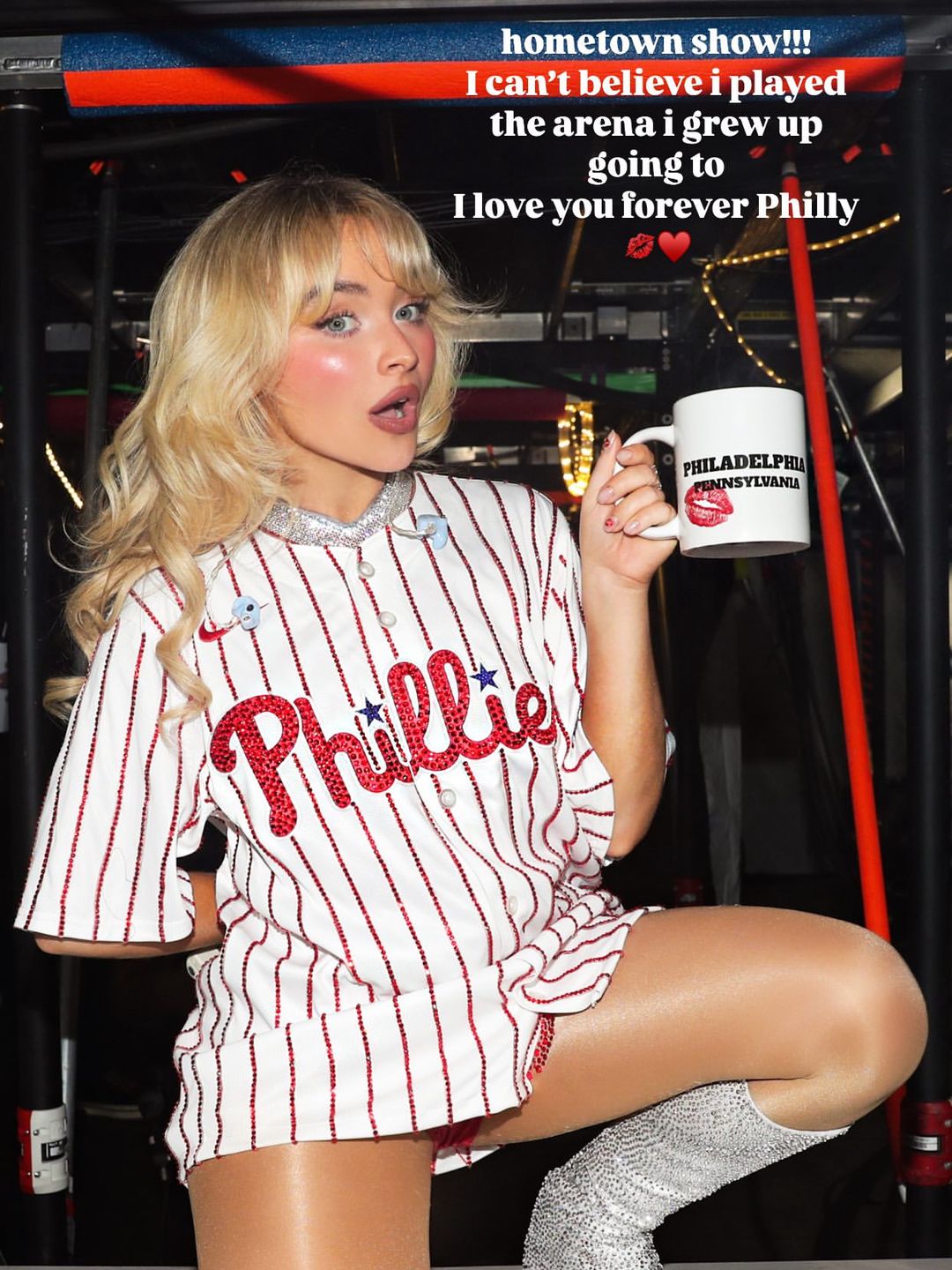 Sabrina Carpenter poses in a custom Phillies baseball shirt and platform boots backstage 