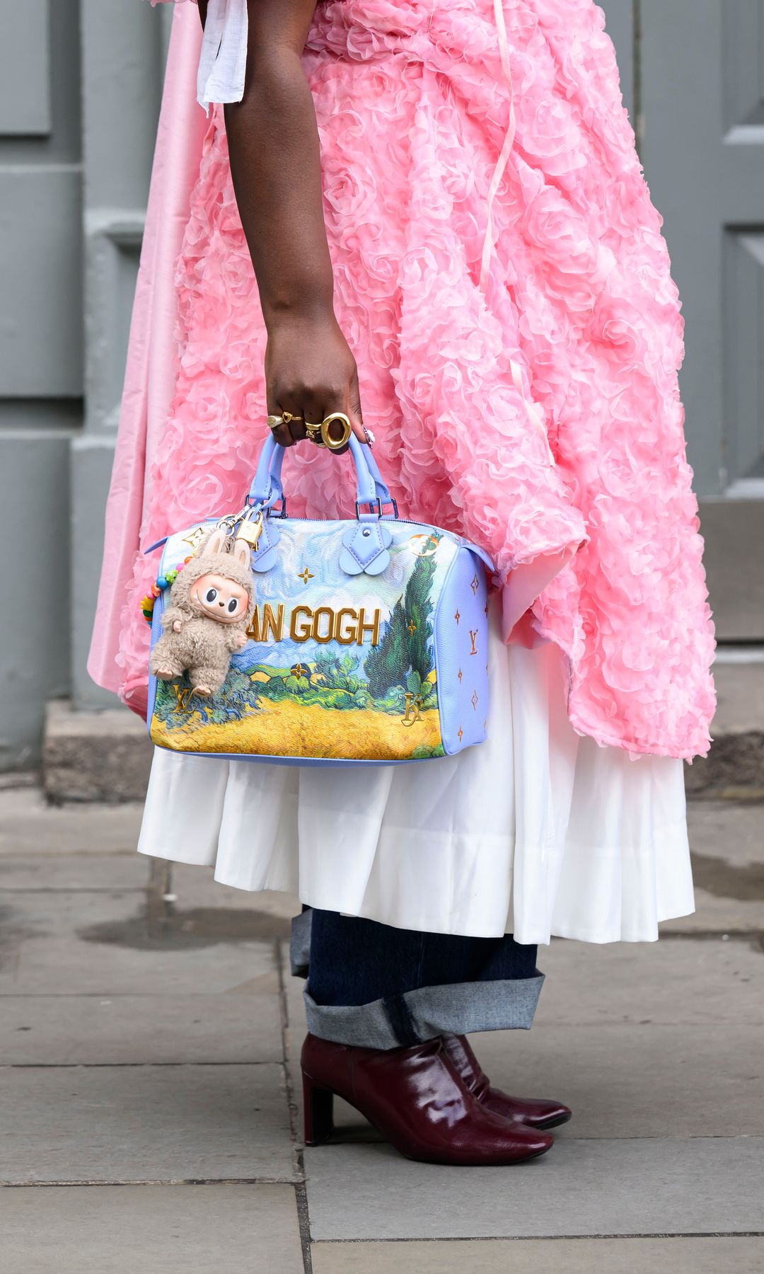 Luena Gama wears a Sister Jane dress, Louis Vuitton bag, Burgundy patent ankle boots and dark blue jeans during London Fashion Week February 2025 at the Bora Aksu show