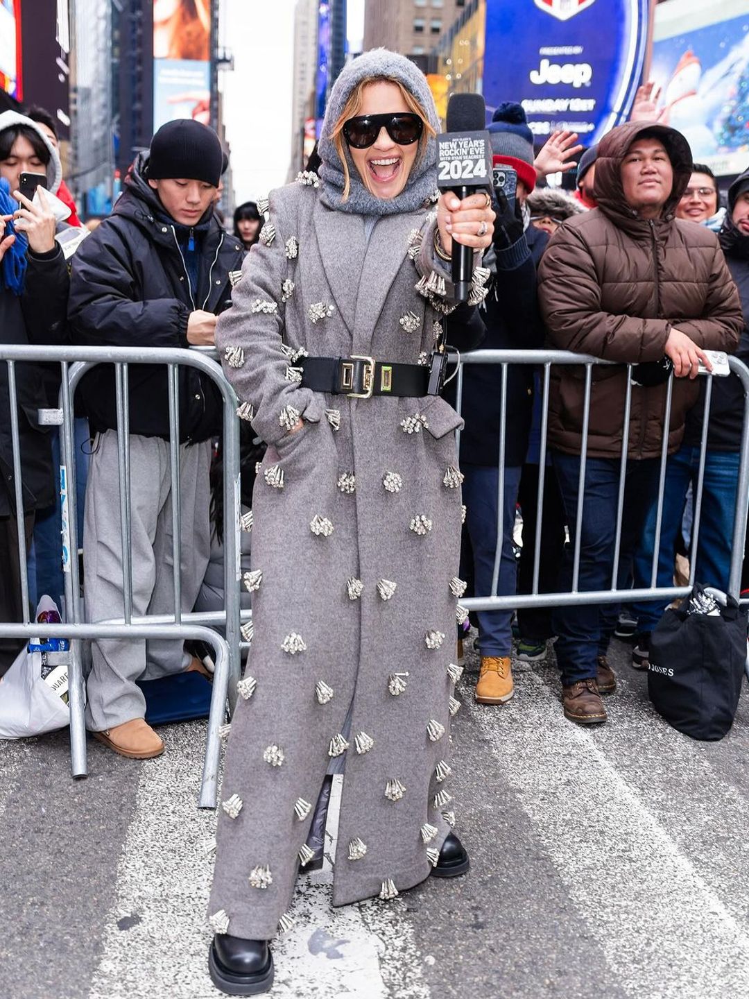 Rita Ora poses in a long grey coat in times square, NYC