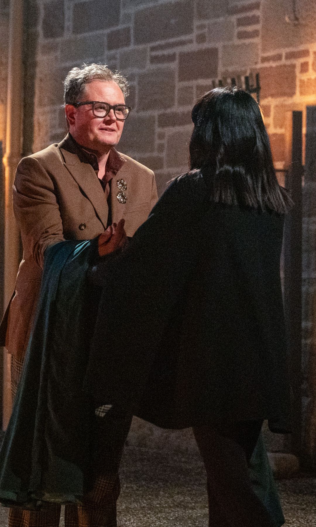 Alan Carr recieving the Traitors cloak from Claudia Winkleman