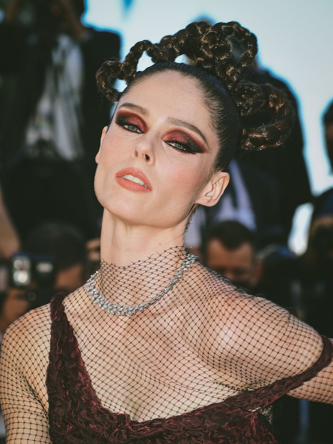 Coco Rocha with red smoky eyeshadow and elaborate braided hair 