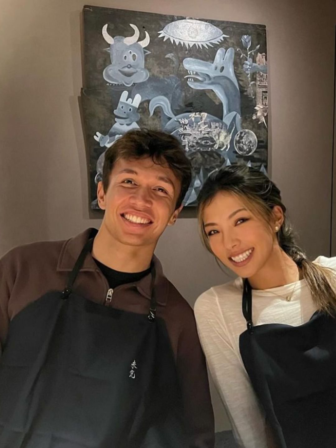 Alexander Albon and Lily Muni in aprons