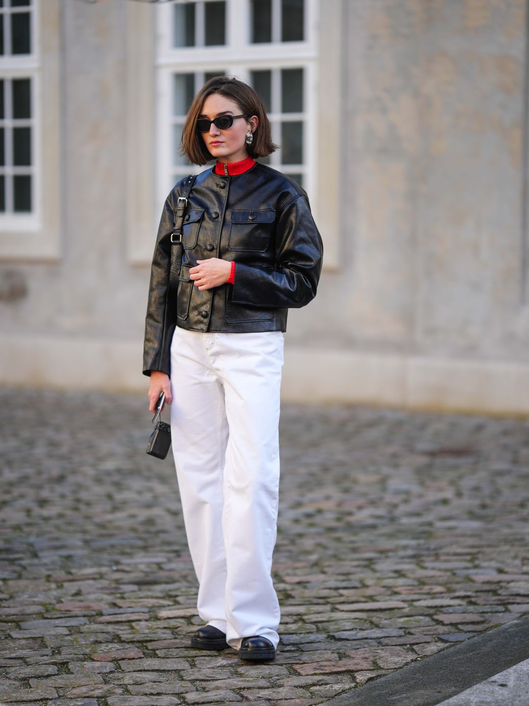 Fashion week guest wearing white jeans with a black leather jacket 