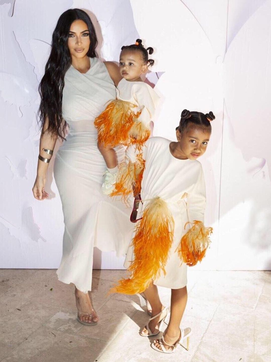 Chicago twinning in a white dress with orange tassels with her mom and sister