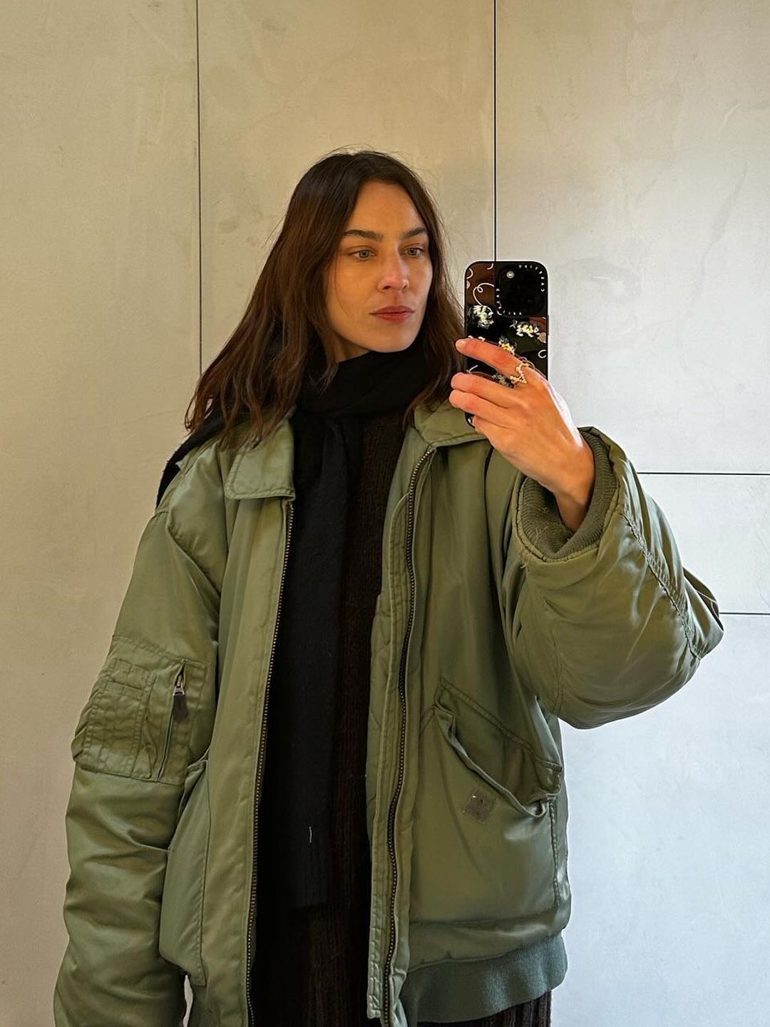 Alexa Chung poses in a green bomber jacket for a mirror selfie