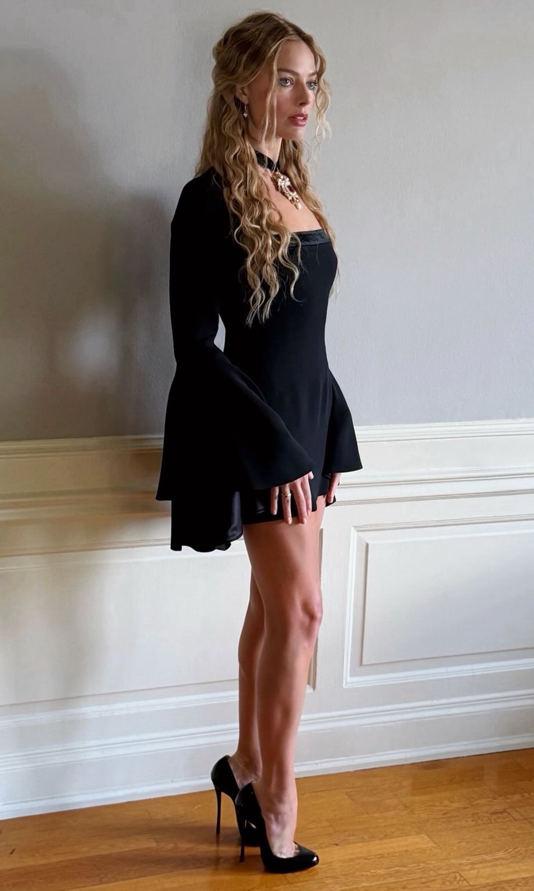 Margot Robbie posing in a black Roberto Cavalli dress