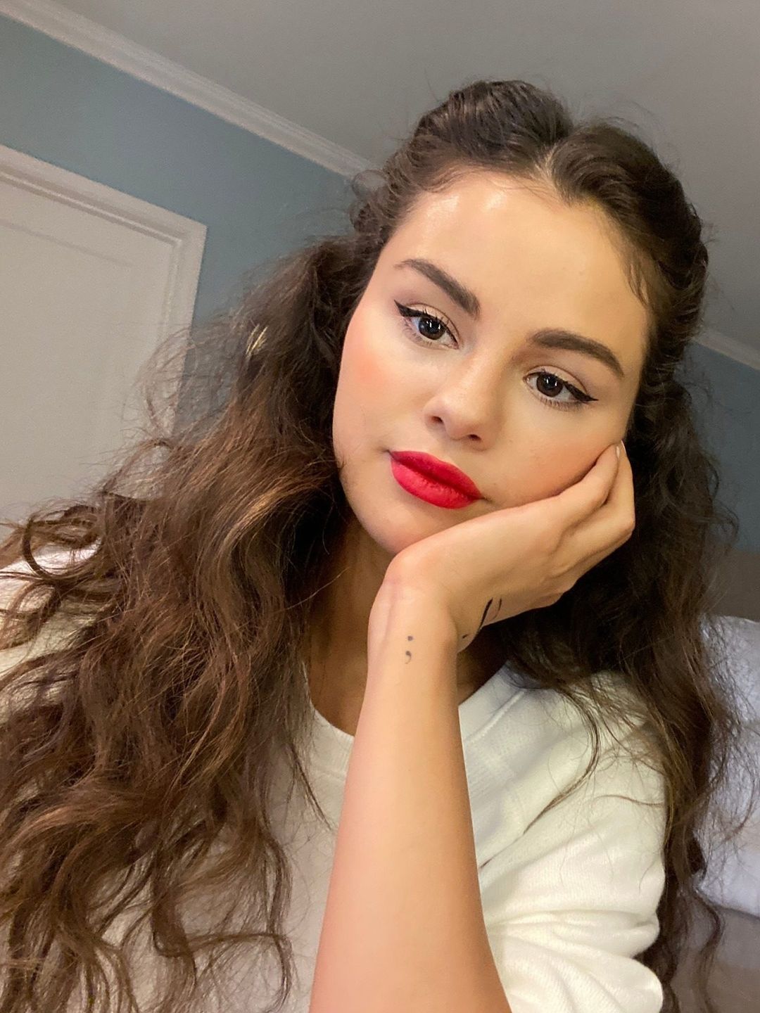 Selena Gomez shares a selfie wearing red lipstick