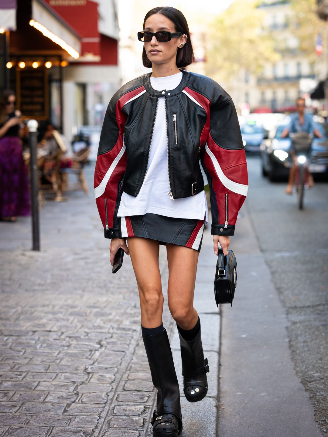 Woman wearing black, white and red A-line skirt with moto jacket 