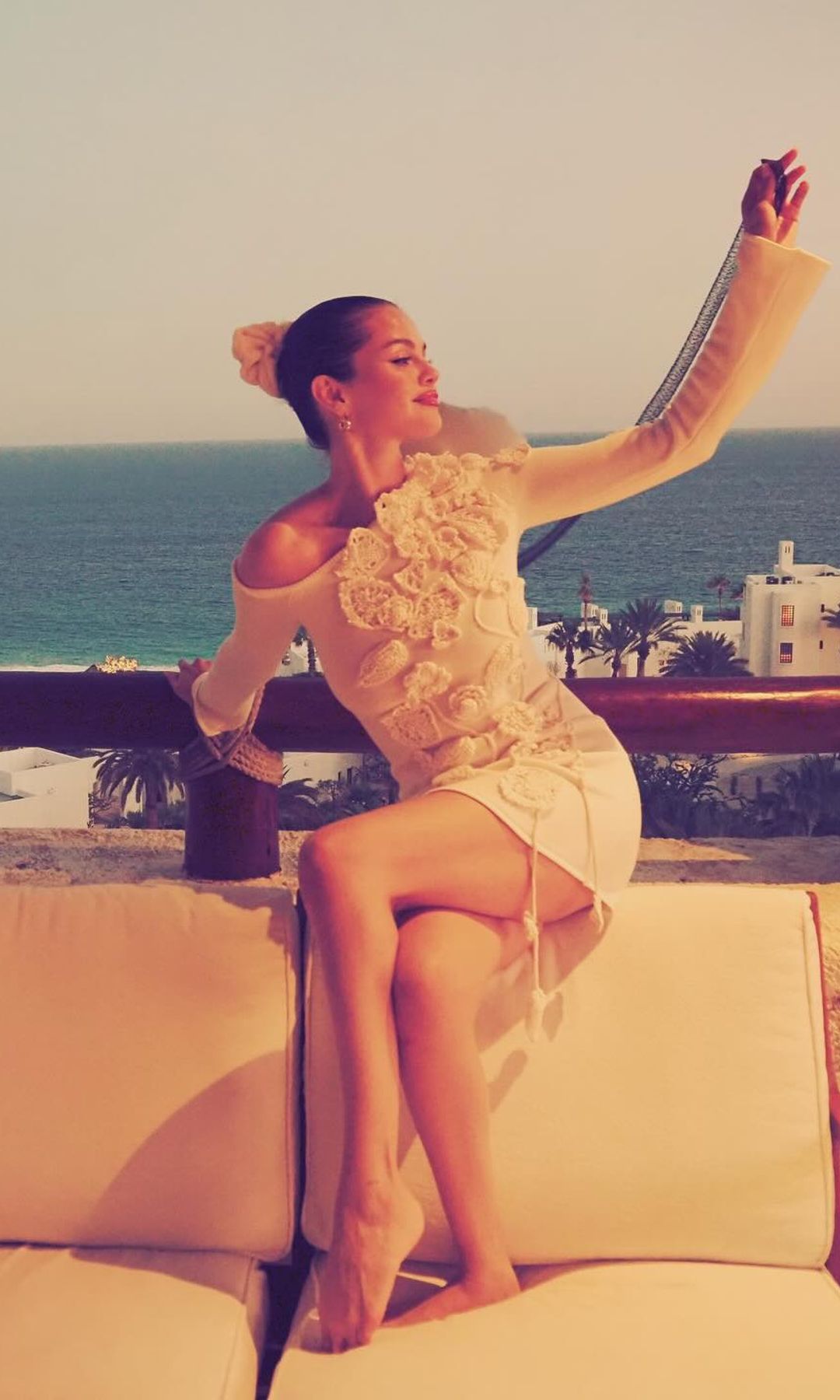 Selena Gomez poses in a crochet mini dress at the beach