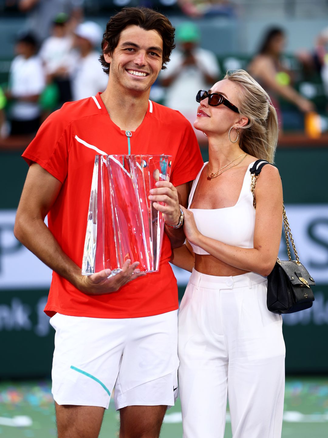 Taylor Fritz of the United States holds his winners trophy with his girlfriend Morgan Riddle