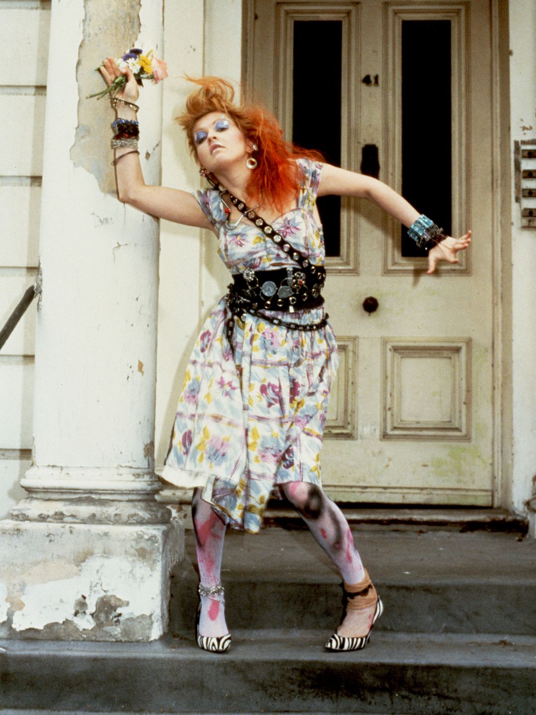 Cyndi Lauper wearing a colourful dress with layered chain belts 