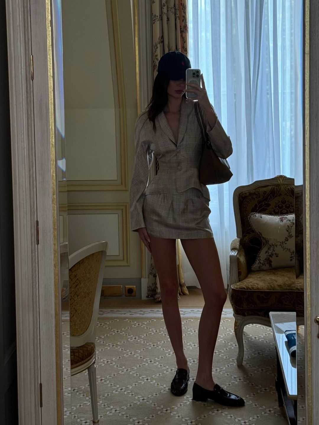 Kendall Jenner poses in a mini skirt and matching blazer in her Paris hotel room