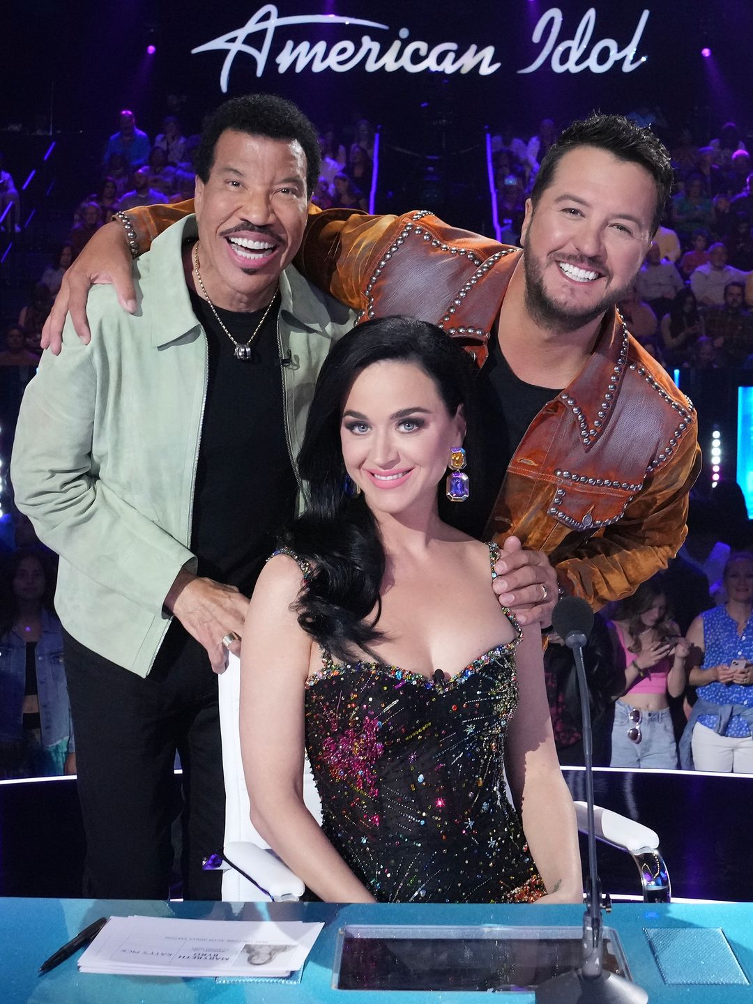 The singer smiling with her fellow Idol judges Lionel and Luke stood behind her