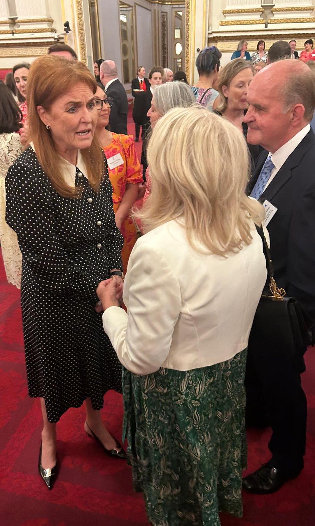 Sarah Ferguson talking to two people inside Buckingham Palace