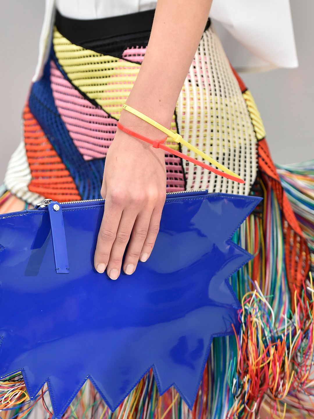 Neon yellow and orange cable ties are worn as bracelets on the Christopher Kane Spring Summer 2016 catwalk