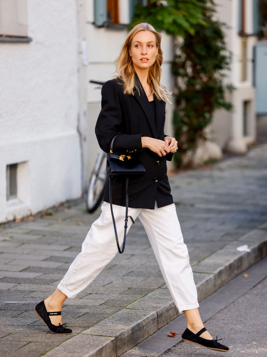 Marlies-Pia Pfeiffhofer wears a black blazer, white cropped trousers and ballet flats 