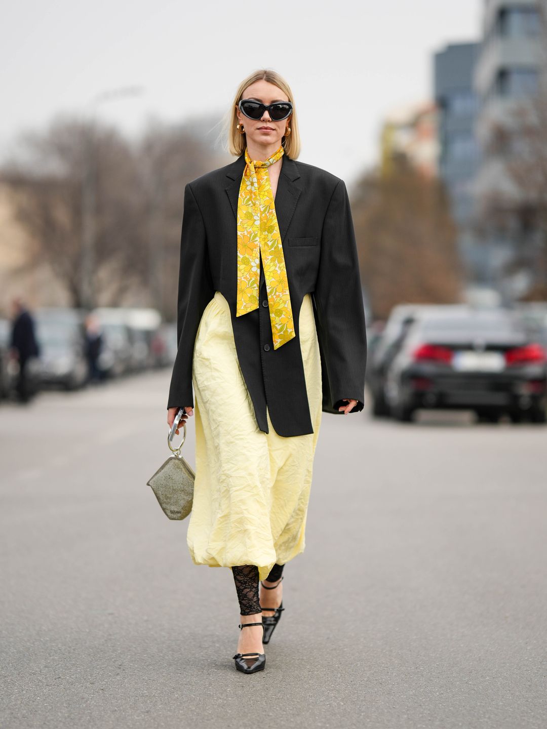 Woman wearing black blazer over yellow dress and lace footless tights