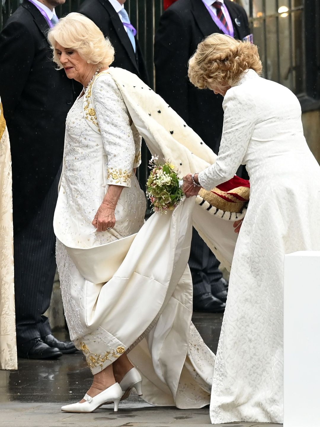 Queen Camilla's lady in attendance fixes her dress ahead of the coronation at Westminster Abbey