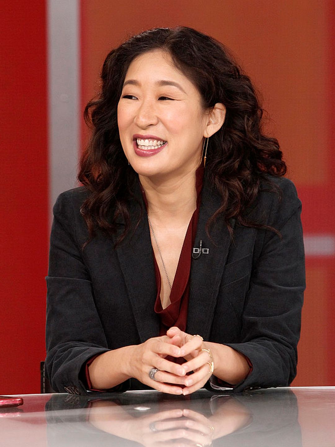 Sandra Oh smiling on a talk show