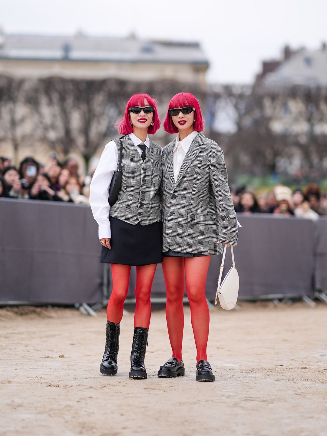 Ami and Aya are seen ; a guest wears sunglasses, red lipstick, a white shirt, a gray houndstooth printed pattern oversized blazer jacket , a mini skirt, red tights, a Dior bag, leather shoes ; a guest wears a waistcoat, outside Dior