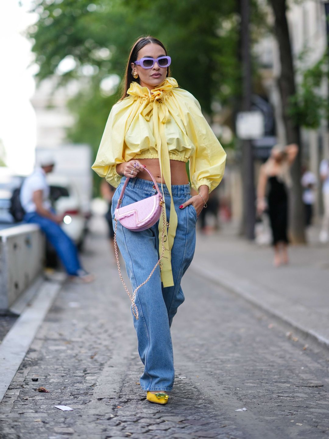 A guest styled a high impact yellow blouse alongside purple shades and light-wash jeans.