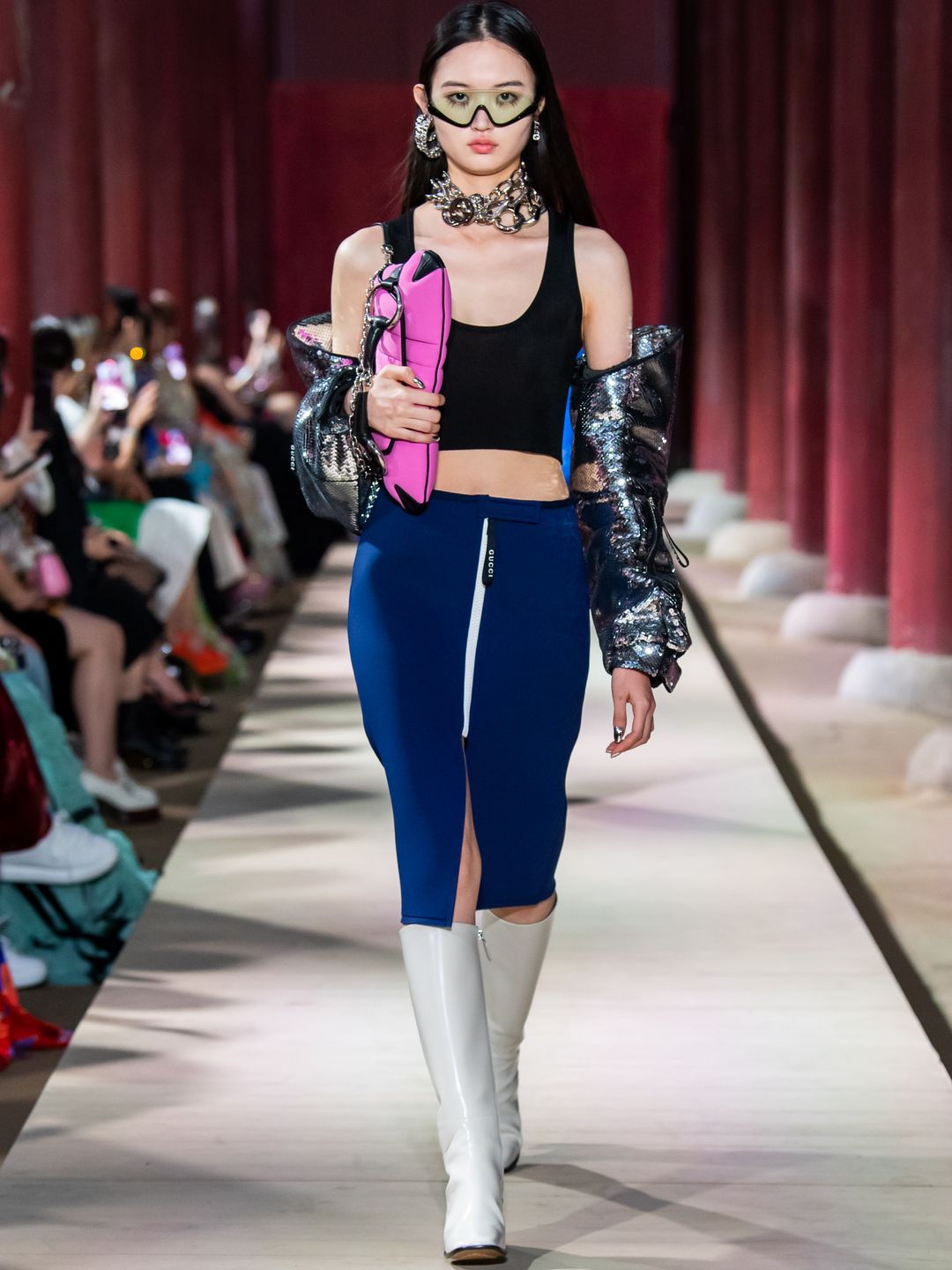  Gucci model wearing sporty navy skirt, white boots and tinted shades 