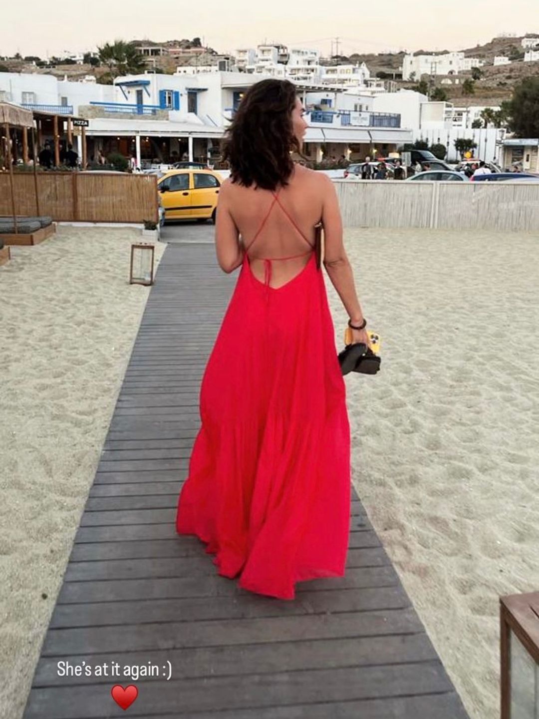 Lily James wearing a vibrant red backless maxi 