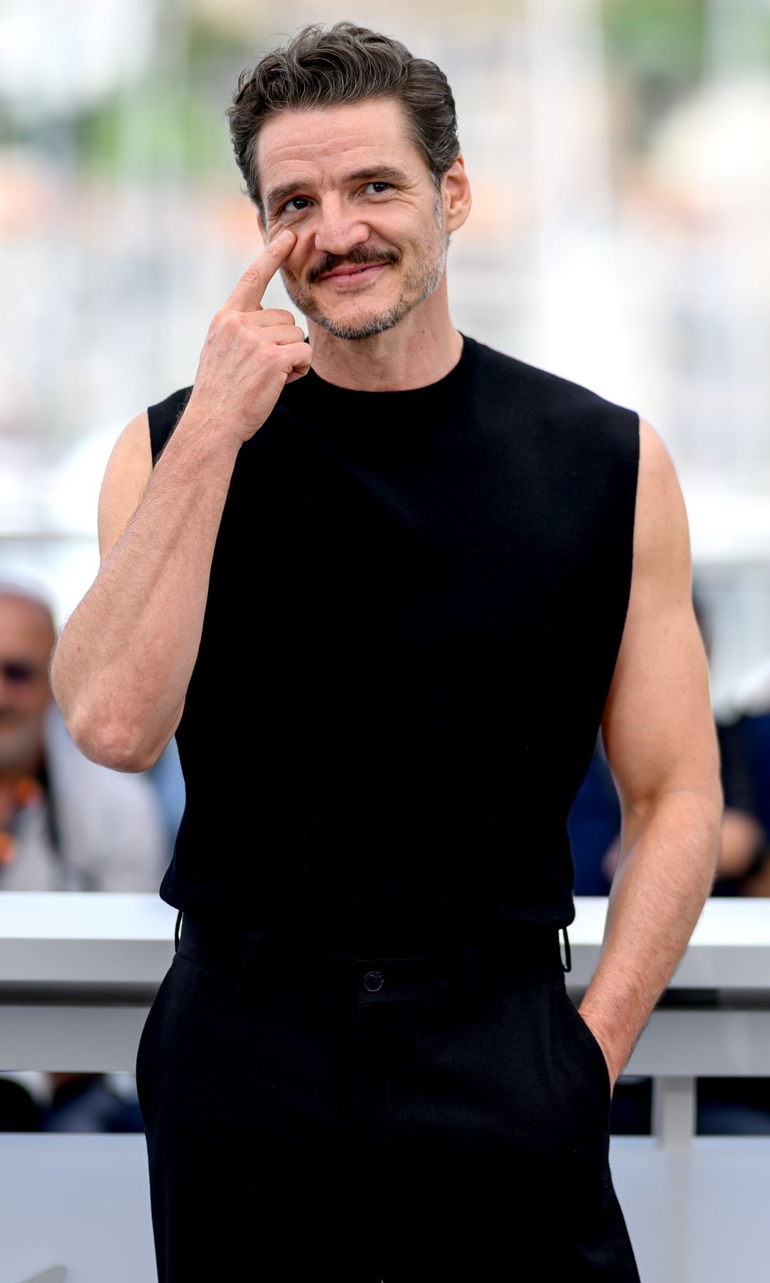 Pedro Pascal in a black tank top and trousers