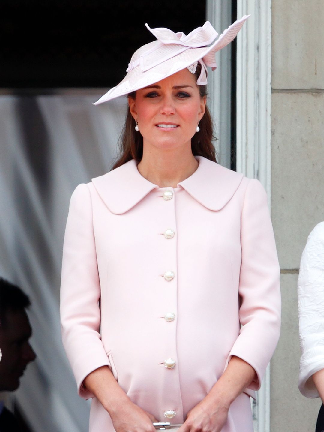 A pregnant Kate Middleton in a baby pink dress