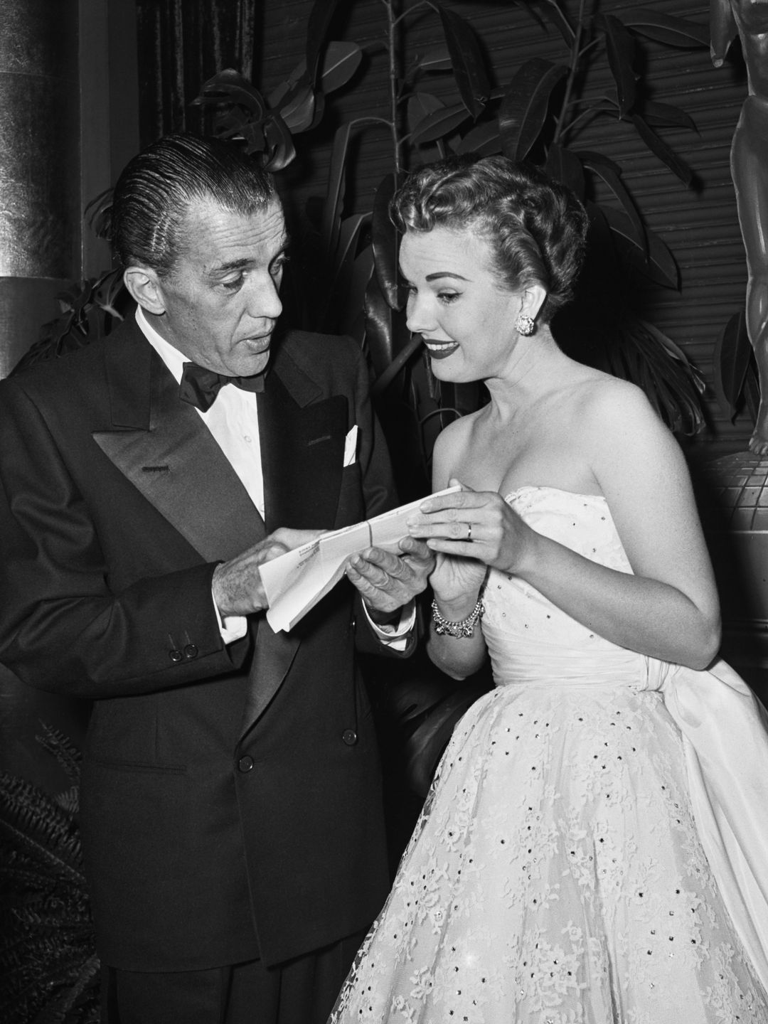 American television presenter and journalist Ed Sullivan (1901-1974), wearing a tuxedo and bow tie, with American actress and singer Gale Storm (1922-2009), wearing an off-the-shoulder evening gown, attend an Emmy awards ceremony, United States, circa 1955. (Photo by Frank Worth/Graphic House/Archive Photos/Getty Images)
