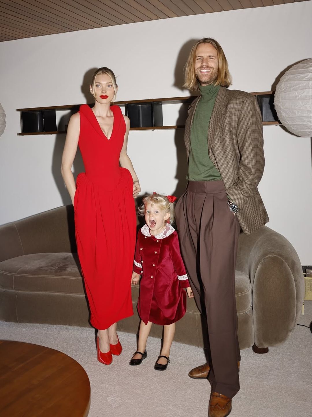 Elsa Hosk's family wearing coordinated red, green, and velvet outfits. The playful yet polished look captured holiday cheer.