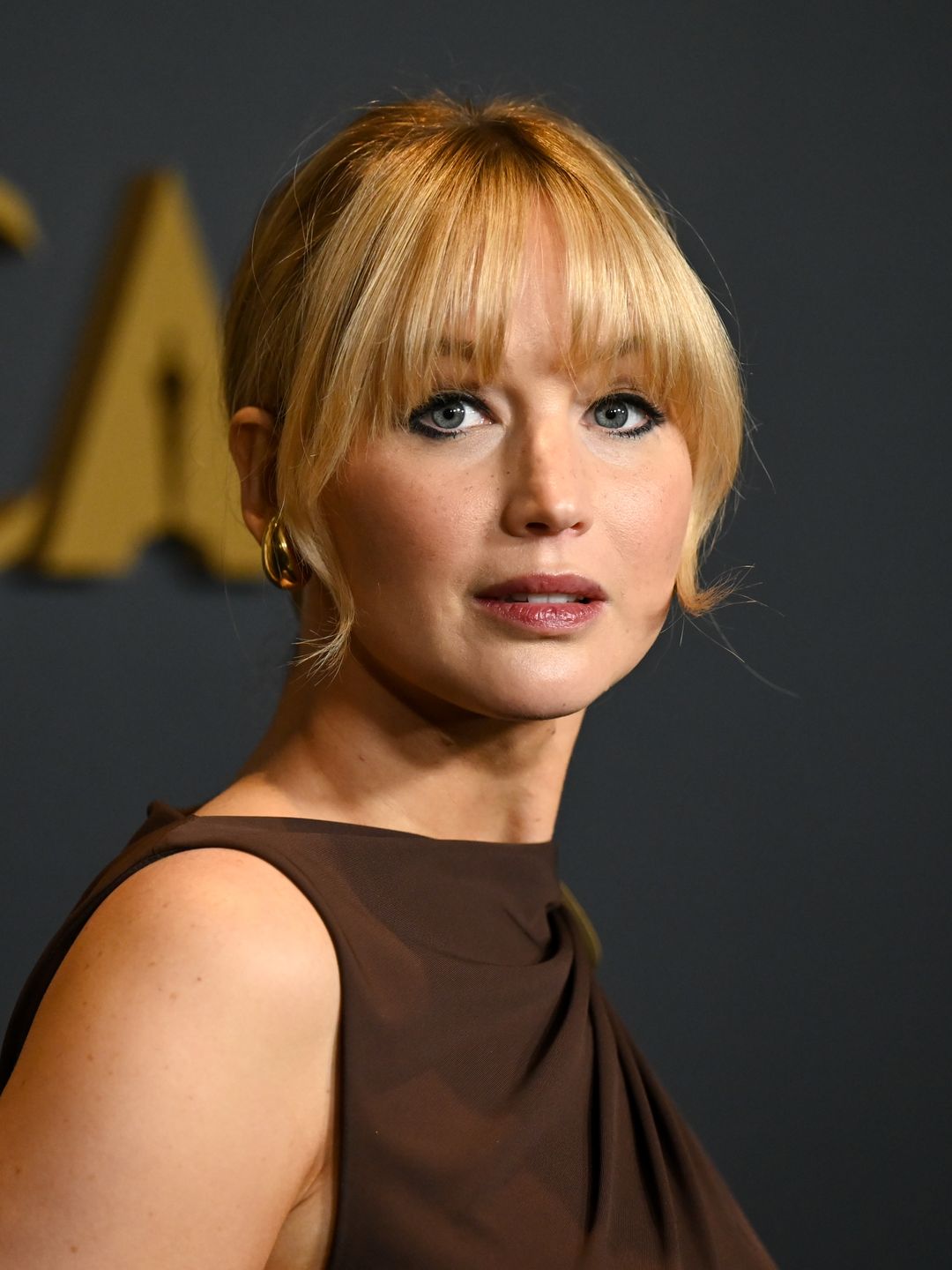 Jennifer Lawrence with bangs and brown makeup 