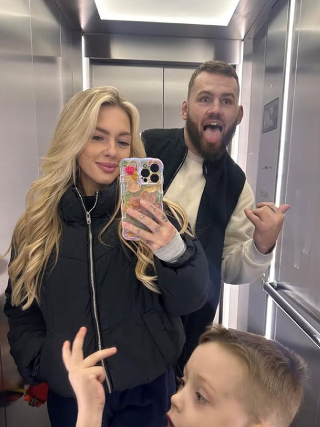 Luke Cowan-Dickie posing with partner Rose and son Arlo in an elevator