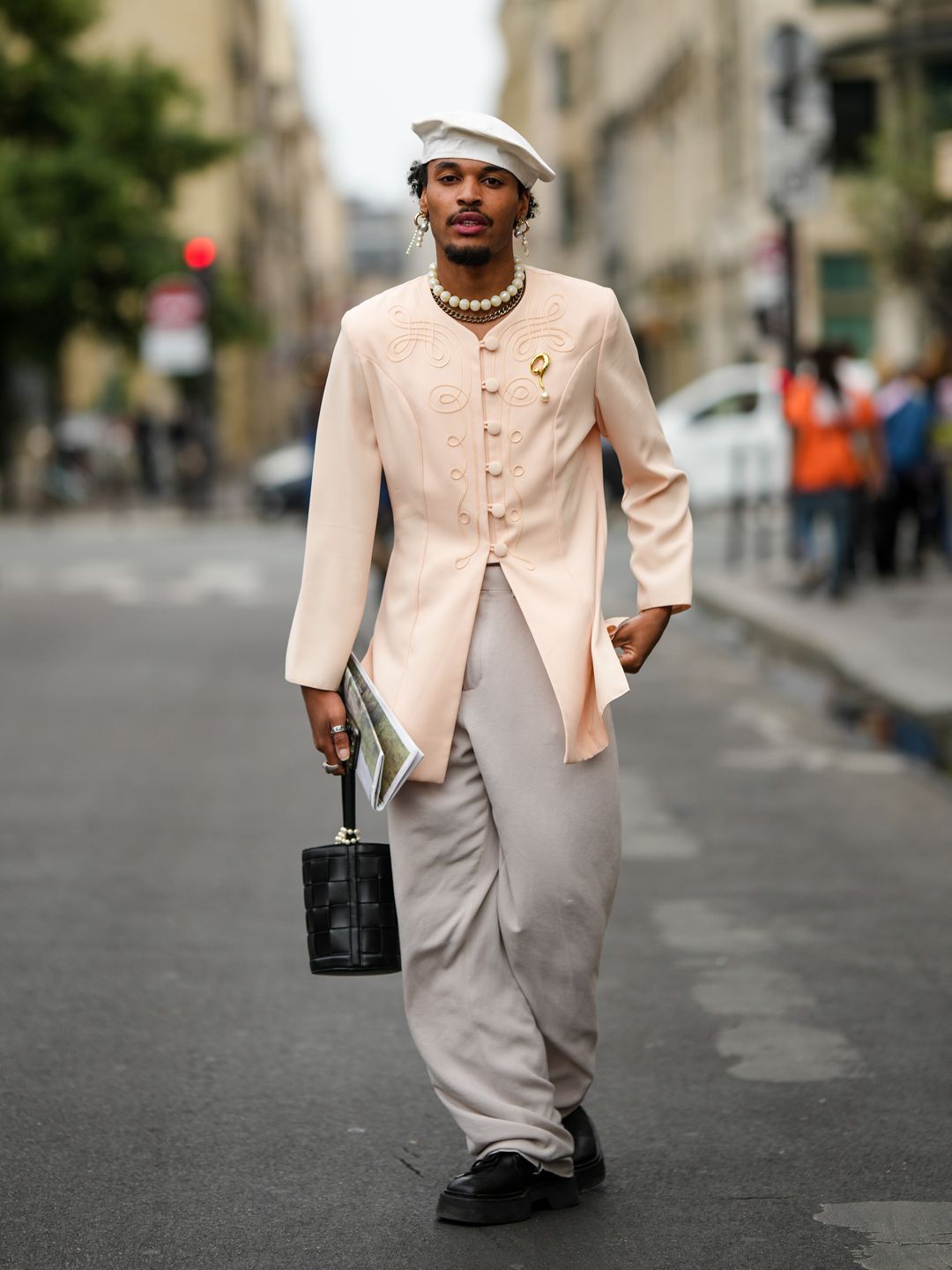 A guest wears a peach buttoned jacket outside the Casablanca show, during Paris Fashion Week SS23