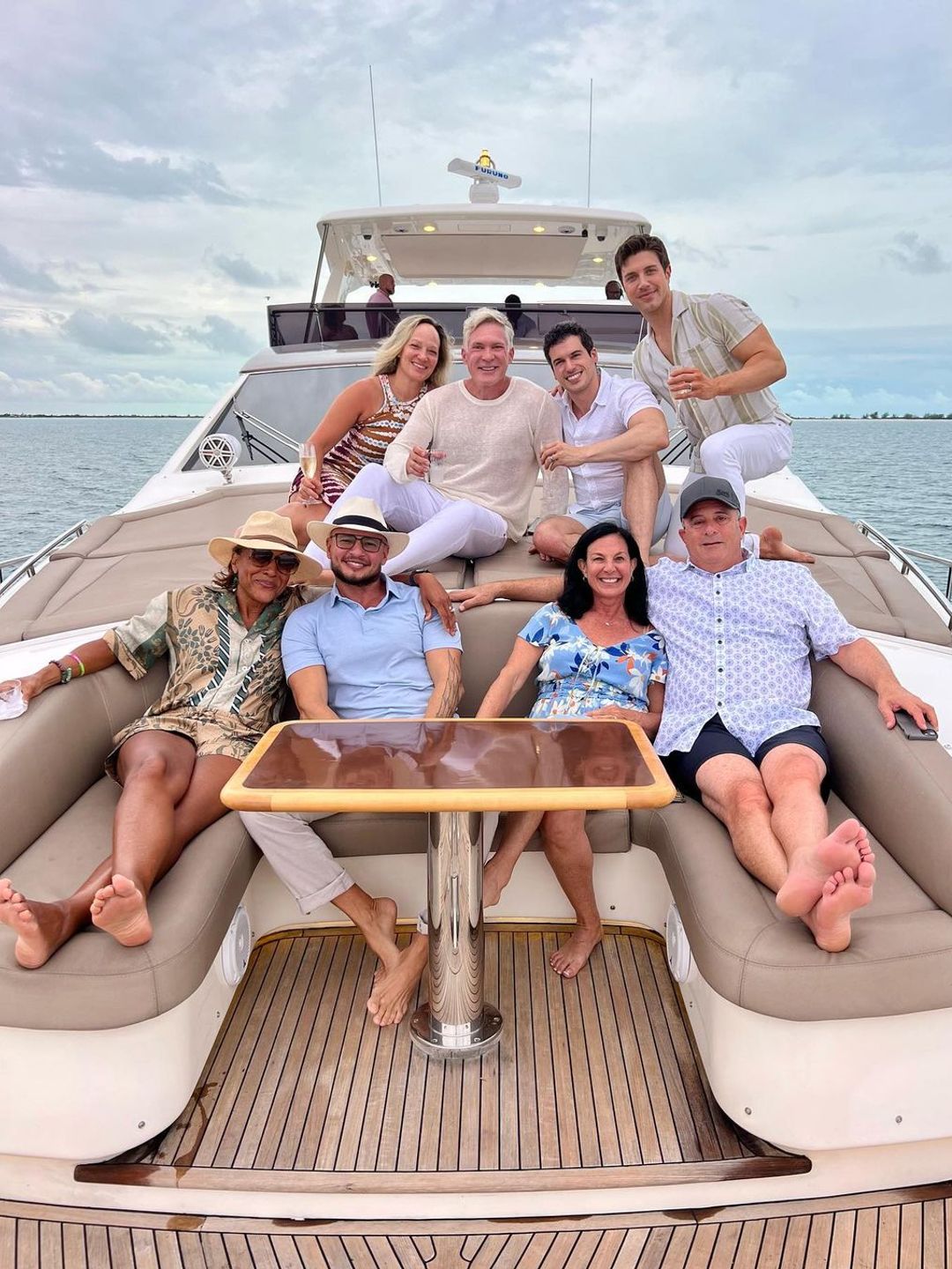 The 'Travel Squad' all sat posing together on the back of a yacht