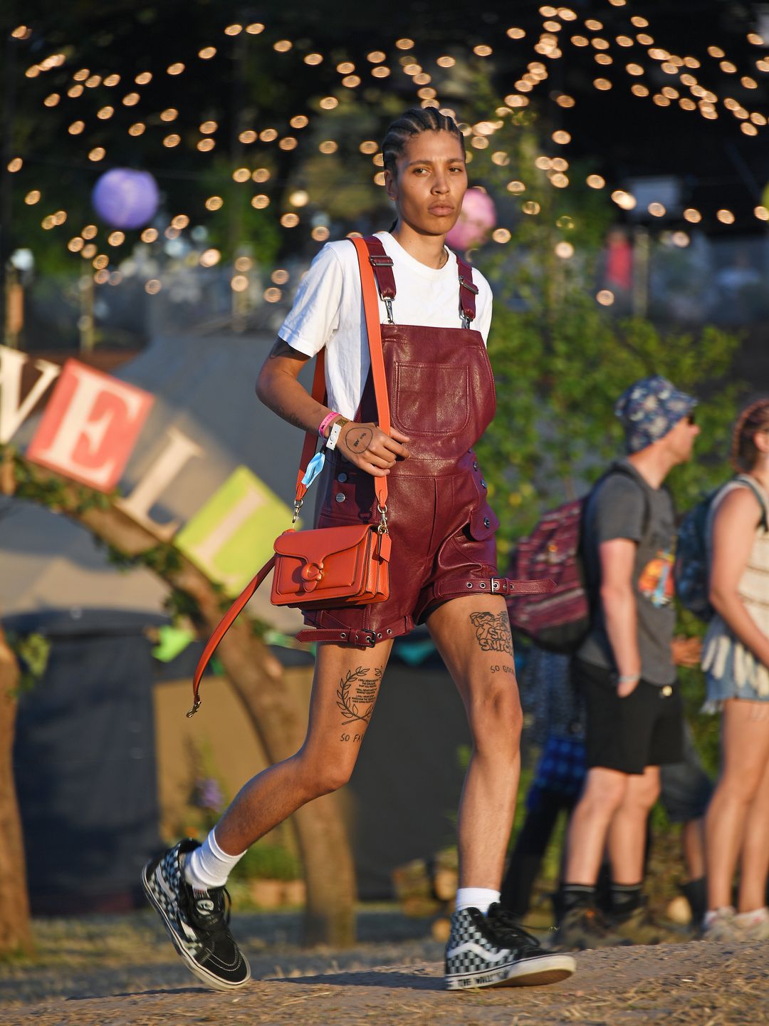 Model Kai-Isaiah Jamal attended day three of Glastonbury wearing maroon dungarees, white oversized t-shirt and a Coach bag.