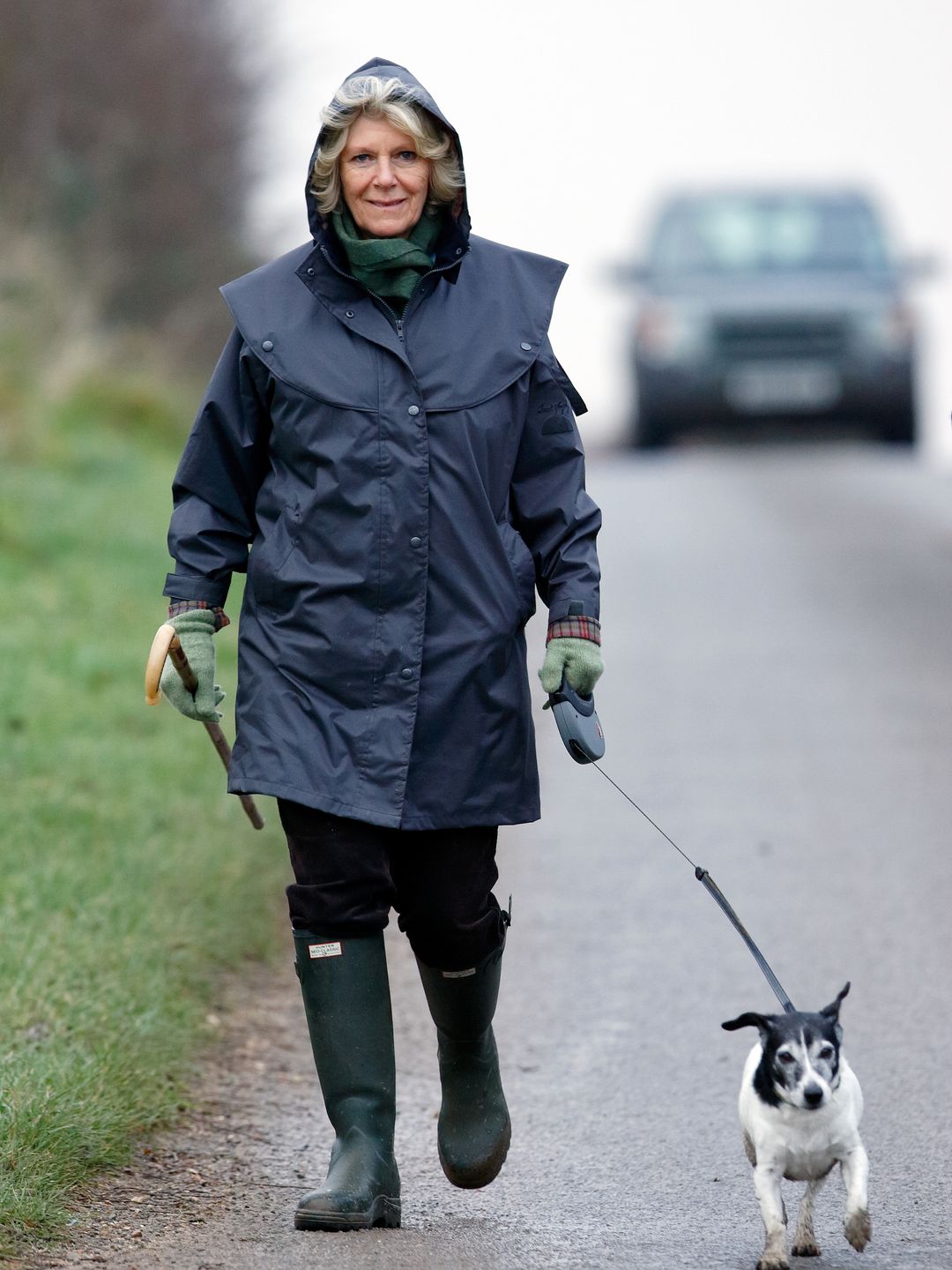 woman walking dog in blue coat 