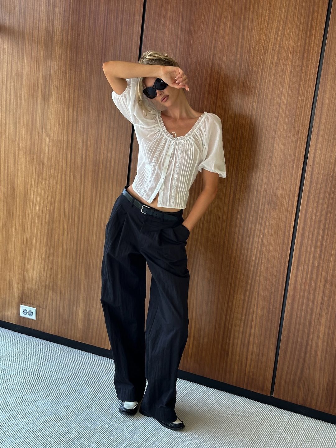 Elsa Hosk poses in a pair of navy trousers and a white top on her Instagram