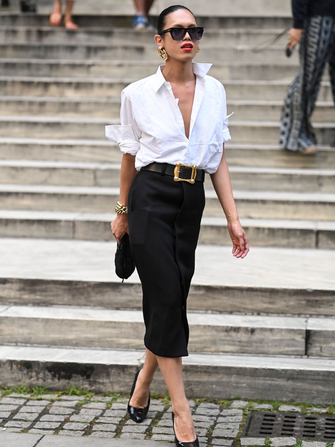 A fashion week guest rocks a white shirt with a form-fitting skirt 