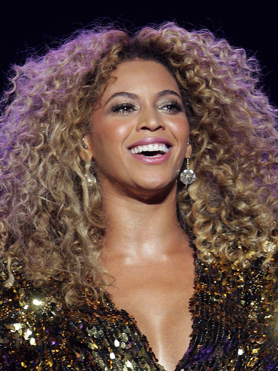 Beyonce with shimmery eyeshadow and golden blonde curls 