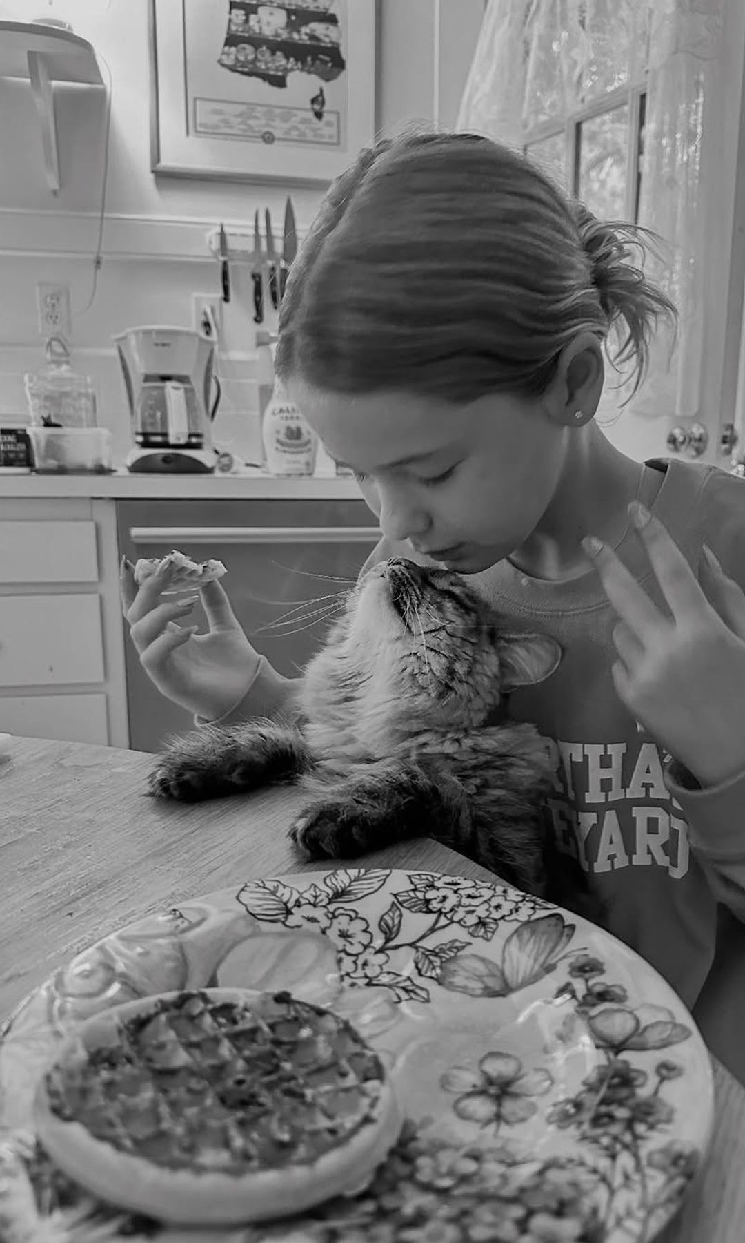 Jenna Bush Hager's daughter Mila plays with their cat Maisy Moo while in their kitchen eating breakfast, shared on Instagram