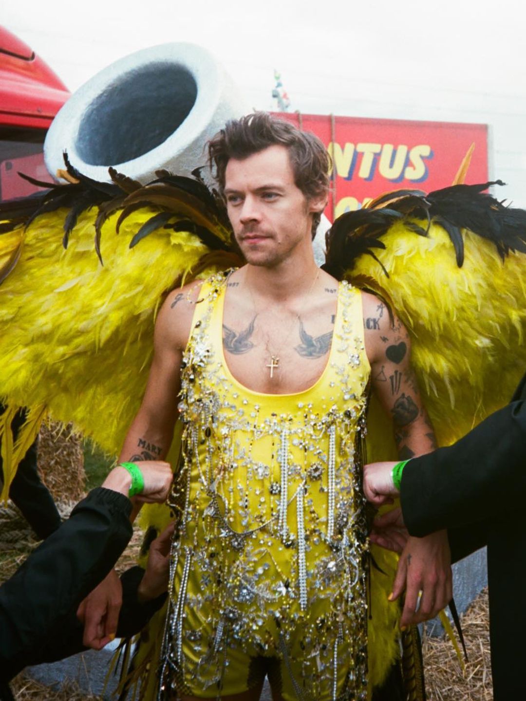 Harry Styles shares a BTS of his Daylight music video, wearing a yellow beaded jumpsuit and feather wings