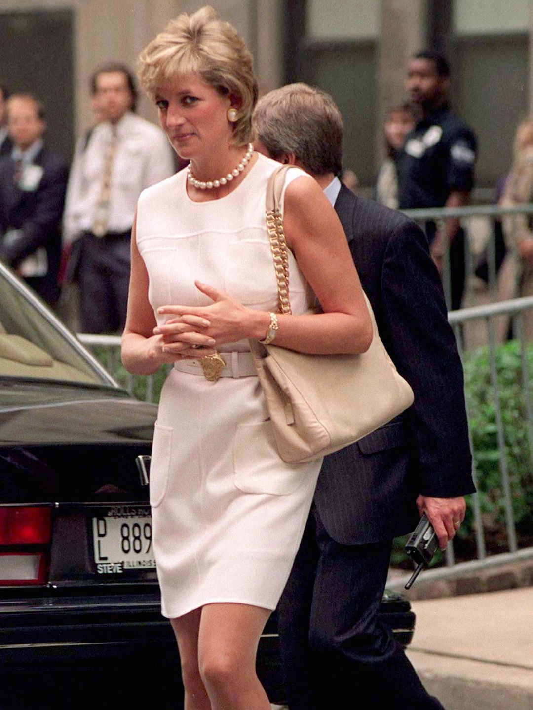 Princess Diana opted for a cream shift dress, a pearl necklace and a beige shoulder bag 