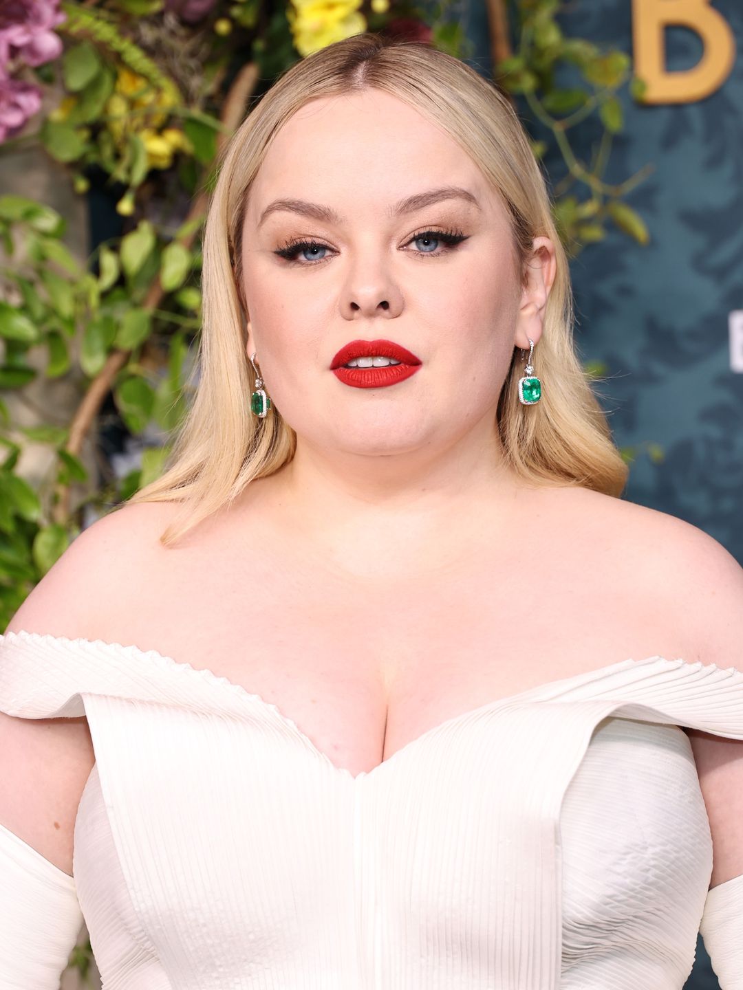 Nicola Coughlan attends Netflix's "Bridgerton" Season 3 World Premiere at Alice Tully Hall, Lincoln Center on May 13, 2024 in New York City in a white gown, red lip and emerald green earrings